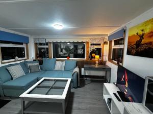 Mullenbeg Cross RoadsStardust Cabin的客厅里有一张蓝色沙发和一台电视