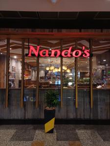 a nandos restaurant with a neon sign in the window at Kuala Lumpur Grand service suite at Times Square in Kuala Lumpur