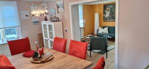a kitchen and dining room with a table and red chairs at Ferienhaus Hof in Remscheid