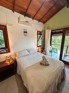 Casa Dendê - Arraial D'Ajuda في ارايال دايودا: غرفة نوم عليها سرير مع زوج من الاحذية +60 صورة