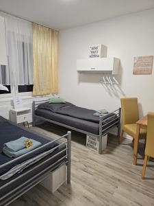 a room with two beds and a table and chairs at Ferienwohnung in Krefeld Monteurzimmer Gästezimmer Messezimmer Apartment in Krefeld in Krefeld