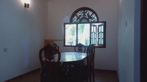 a dining room with a table and chairs and a window at The Nightingales in Dickwella +14 photos