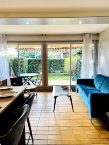 a living room with a blue couch and a table at Le Mouette - Seaside in La Rochelle
