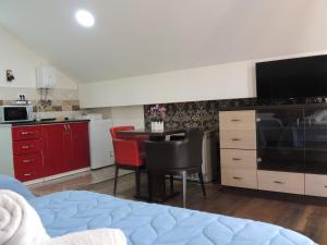 a room with a bed and a kitchen with a table at Apartmani Beograd 43 in Belgrade