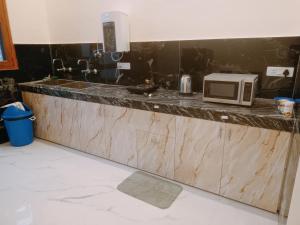 a kitchen with a counter with a microwave on it at Anand Kunj in Chandīgarh