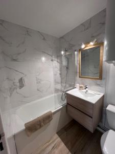a bathroom with a tub and a sink and a shower at Plage Cabourg 5bis in Cabourg +5 photos