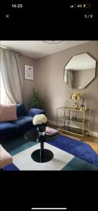 a living room with a blue couch and a table at Cute apartment in London