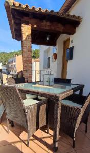 a glass table and chairs on a patio at Casa Rural La Tejeria in Villora