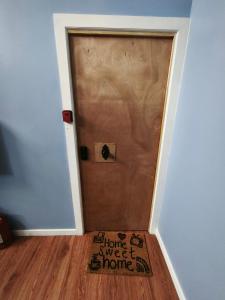 a brown door with a welcome sweet home sign on it at Aventura Patagonica 3 in Punta Arenas