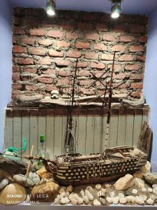 a boat sitting on a pile of rocks next to a brick wall at Aventura Patagonica 3 in Punta Arenas