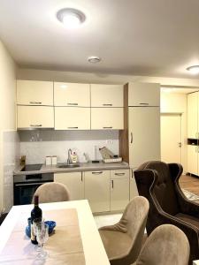 a kitchen with a table and some chairs and a counter at Pine forest view apartment in Kolašin