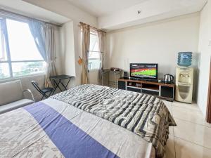 ein Schlafzimmer mit einem Bett und einem Fernseher darin in der Unterkunft Strategic MTH Square Apt 1BR with Wi-Fi, Pool & Gym by 2ndHome in Jakarta