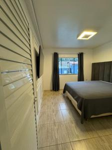 1 dormitorio con 1 cama y puerta corredera en Casa piscina com hidromassagem, en Porto Belo 11 fotos más
