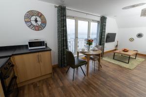 a living room with a table and a clock on the wall at Lerwick Penthouse Apartment in Lerwick