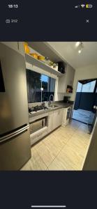 cocina con nevera de acero inoxidable y suelo de baldosa en Casa piscina com hidromassagem, en Porto Belo