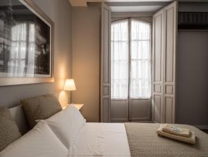 a bedroom with a white bed and a window at U-Sense Sevilla Santa Cruz in Seville