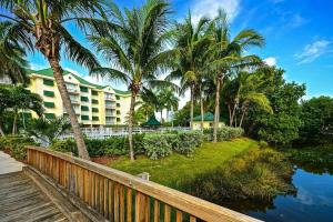 a resort with palm trees next to a body of water at Cat Island Suite - Sunrise Suites in Key West