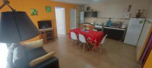 a kitchen with a red table and chairs in a room at Departamentos Ensueños in Río Gallegos