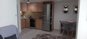 a kitchen with a stainless steel refrigerator and a table at La casa bella di Chalkida 2 in Chalkida