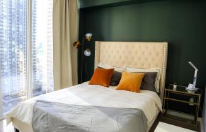 ein Schlafzimmer mit einem großen Bett mit orangefarbenen Kissen in der Unterkunft Stunning suite in downtown perfect for businesses trips and small families in Toronto