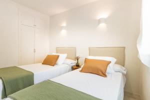 2 camas en una habitación de color blanco y verde en Resting of Peace by the Sea, en Denia