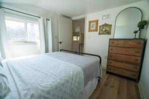 a bedroom with a bed and a dresser and a window at Hadley Hideaway Cottage in Hadley