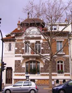 a building with a car parked in front of it at Residence Reine - Boulogne - Paris in Boulogne-Billancourt