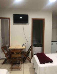 a room with a desk and a tv on the wall at Suíte 101 - Pousada no Centro do Rio in Rio de Janeiro