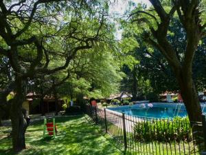 a fence next to a swimming pool in a yard at Hostal La Merced in Villa General Belgrano