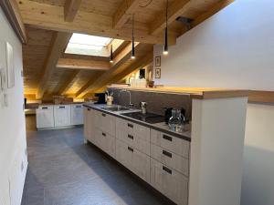 a large kitchen with a sink and wooden ceilings at Casa Delfina in Grosotto