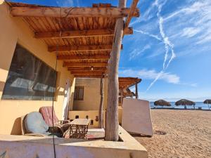 a house on the beach with chairs and tables at ACACIA Camp in Nuweiba