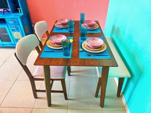 a wooden table with plates and glasses on it at Waterfront Tropical Themed 2 BR in Abu Dhabi +17 photos