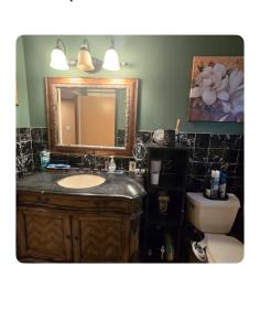 a bathroom with a sink and a mirror and a toilet at Charming relaxed staying in Sacramento