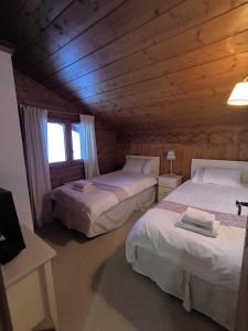 una camera con 2 letti in una baita di tronchi di Chalet Cannon- Mountain Getaway a Les Contamines-Montjoie