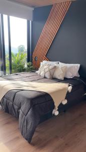 a bedroom with a large bed with a large window at cabaña mulata in La Tebaida