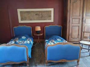 two blue chairs in a room with a table at Aile de la Maison de Chouliou in Balaguères