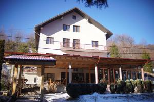 a large white house in the snow in front at Apartments and Rooms Vicko in Brzeće