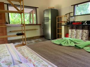 a kitchen with a refrigerator and a bed in a room at PachaMama Flats - Taipu de Fora in Barra Grande