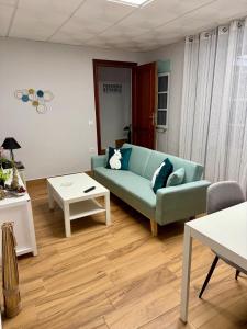 Una sala de estar con un sofá azul y una mesa. en Vivienda rural el gobernador, en Villanueva de los Infantes