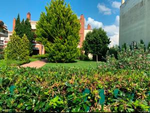 Un jardín con árboles y arbustos frente a un edificio. en Villa Reina 1, en Alexandroupoli