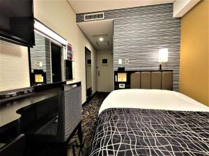 מיטה או מיטות בחדר ב-APA Hotel Hachioji Eki Nishi