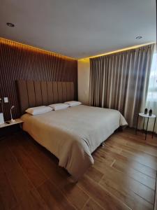 a bedroom with a large bed and a wooden floor at Posada Castillo in Zacatlán