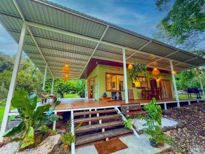 a house with a porch with a roof at Quintaesencia Arte y Naturaleza in Guápiles