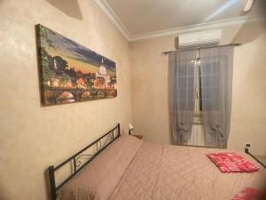 a bedroom with a bed and a picture on the wall at CasadellemeravigliediGiulia in Ostia Antica