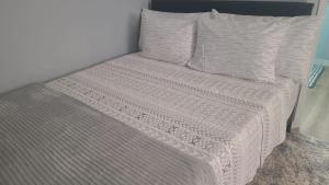 a bed with a white comforter and pillows at Sunburst Studio in Turtle Cove +9 photos