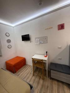 una stanza con un letto, un tavolo e una tv di Loft Largo Gloria locazione turistica a Messina