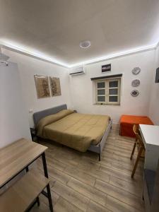 una piccola camera da letto con un letto e un tavolo di Loft Largo Gloria locazione turistica a Messina