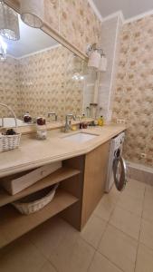 une salle de bain avec un lavabo et une machine à laver dans l'établissement Mega tower 8, à Almaty