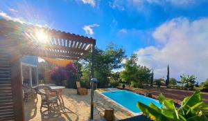 a patio with a swimming pool and a pergola at Casa Nogal in Puntagorda