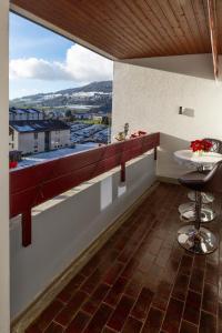 a balcony with a table and a view of a city at Edelweiss in Charmey +8 photos